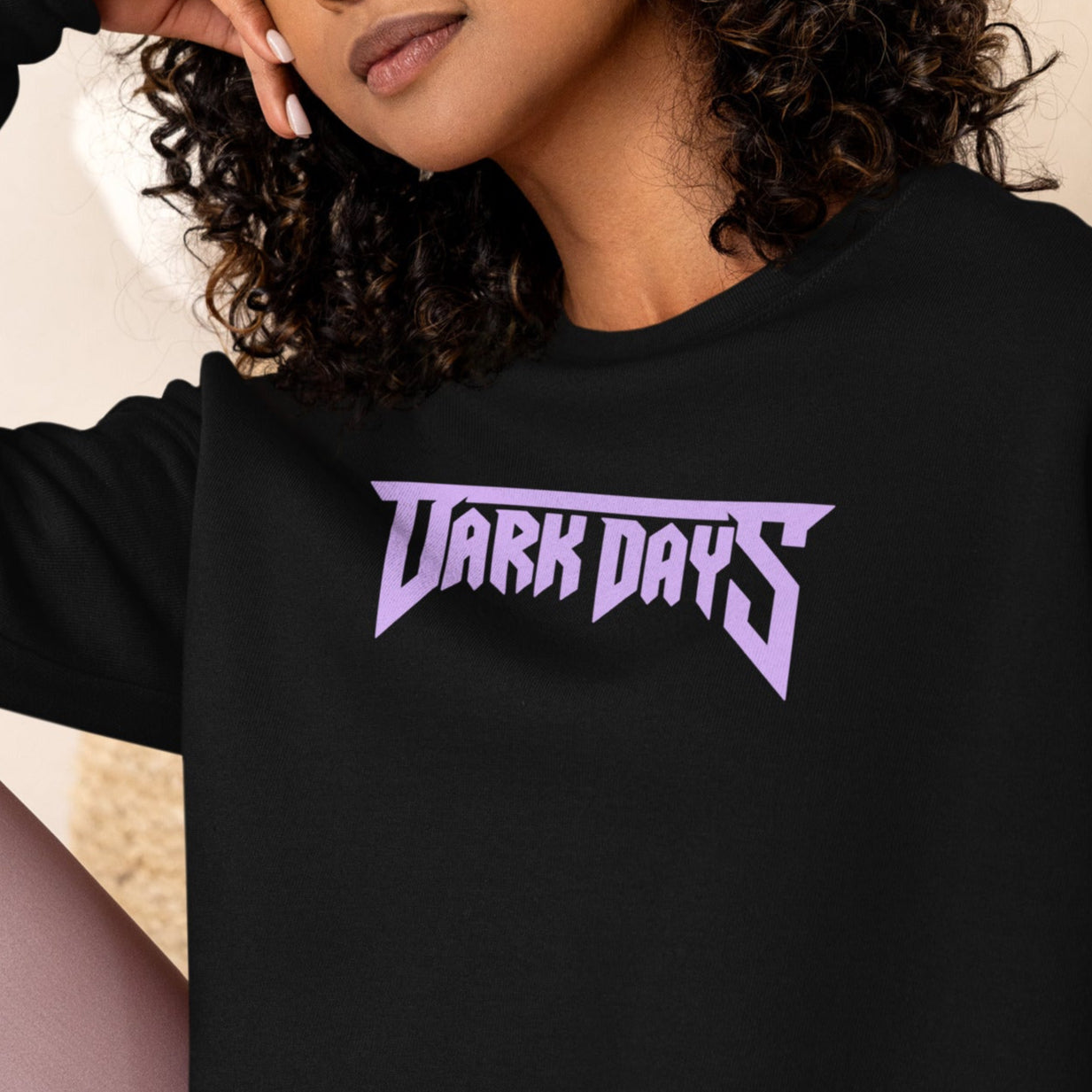 Woman wearing a black sweatshirt with 'Dark Days' text in purple.